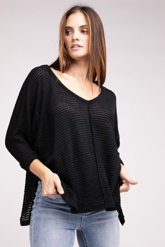 Model wearing a black 3/4 sleeve V-neck hi-low hem jacquard sweater with a stylish, relaxed fit.