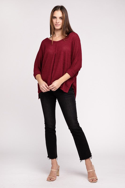 Model wearing a burgundy 3/4 sleeve sweater paired with black jeans, showcasing a casual chic look.