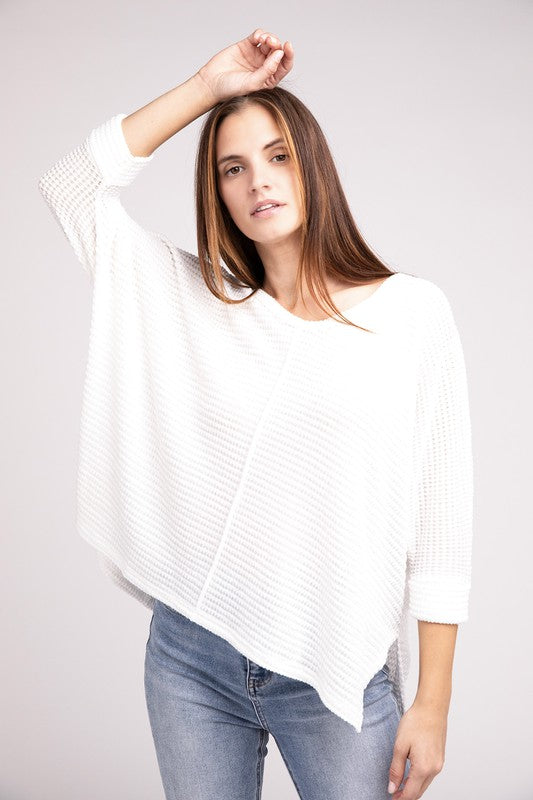 Model wearing a white 3/4 sleeve hi-low hem jacquard sweater, styled casually with light jeans.
