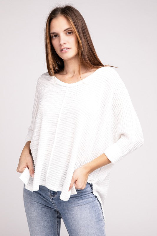 Model wearing a white 3/4 sleeve V-neck hi-low hem jacquard sweater with casual jeans.