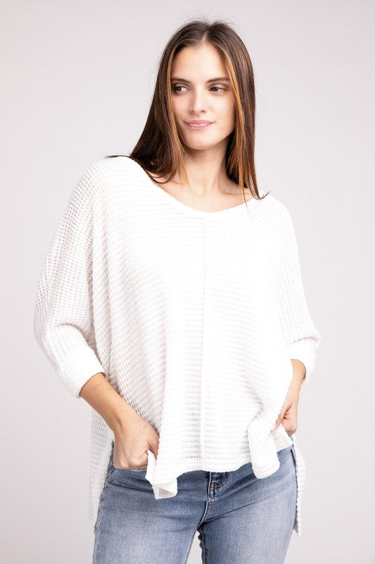 Model wearing a white 3/4 sleeve V-neck Jacquard sweater with a hi-low hem, styled with jeans.