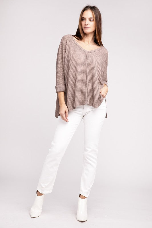 Model wearing a 3/4 Sleeve V-Neck Hi-Low Hem Jacquard Sweater with white jeans and ankle boots.