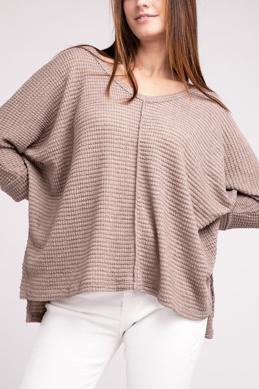 Model wearing a casual beige 3/4 sleeve V-neck hi-low hem jacquard sweater paired with white jeans.