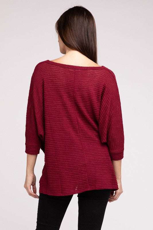 Back view of a woman wearing a burgundy 3/4 sleeve hi-low jacquard sweater with a relaxed fit.