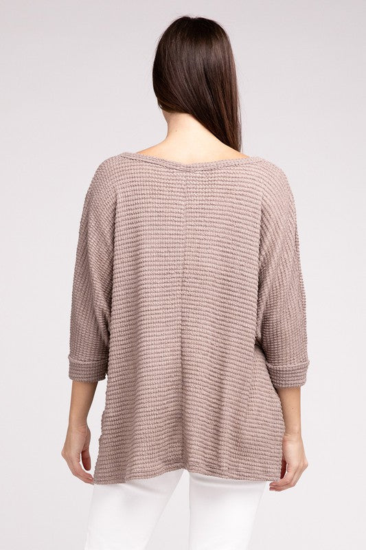 Back view of a model wearing a 3/4 sleeve jacquard sweater in light beige.