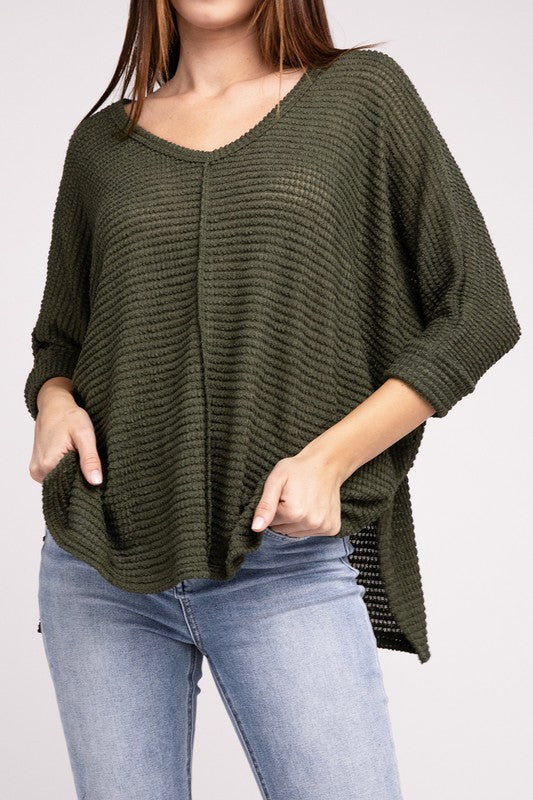 Model wearing a green 3/4 sleeve V-neck hi-low hem jacquard sweater with casual vibe and relaxed fit.