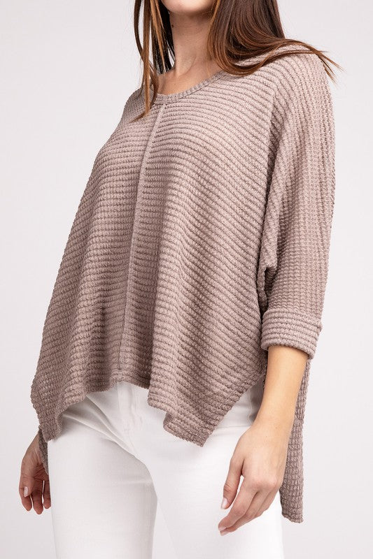 Model wearing a trendy 3/4 sleeve jacquard hi-low hem sweater in beige, paired with white pants for a chic casual outfit.