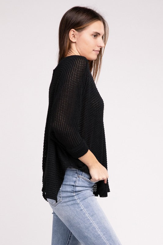 Side view of a model wearing a black 3/4 sleeve V-neck hi-low hem jacquard sweater and light wash jeans.
